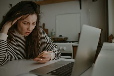 Woman watching on mobile screen with unhappy face scared of the news