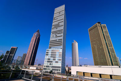 Low angle view of modern buildings against clear blue sky