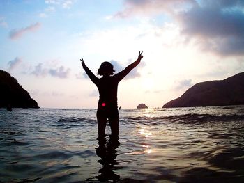 Woman standing on beach against sky