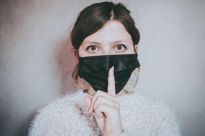 Close-up portrait of a young woman covering face