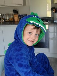 Portrait of smiling boy in costume sitting at home