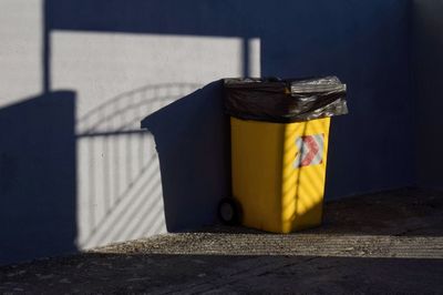 Garbage bin against wall in street