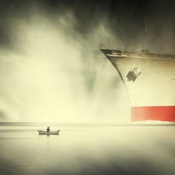 Boat sailing in sea against cloudy sky