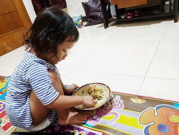 High angle view of cute girl on floor at home