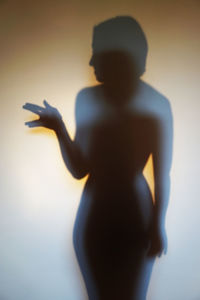 Rear view of silhouette woman standing against gray background