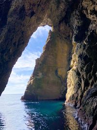 Scenic view of sea and rock formation against sky