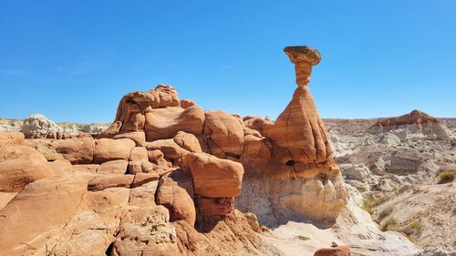 Low angle view of rock formations against clear blue sky
