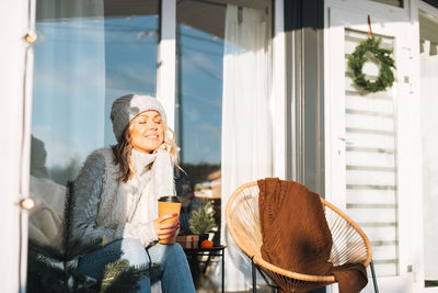 Young woman looking through window