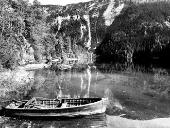 Boat moored on lake against trees