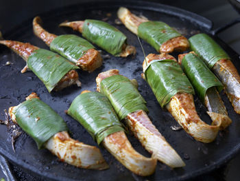 Close-up of fish wrapped in leaves on cooking pan