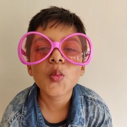 Portrait of boy wearing sunglasses against wall