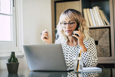 Businesswoman talking on phone at office