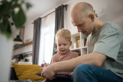 Portrait of young man using digital tablet at home