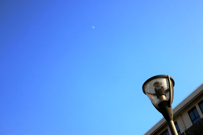 Low angle view of street light against blue sky on sunny day