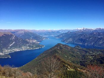 Scenic view of lake and mountains against clear blue sky