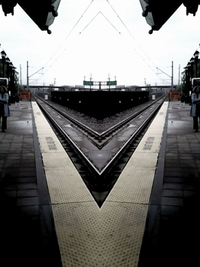 transportation, clear sky, architecture, built structure, railroad station platform, railroad station, city, railroad track, public transportation, building exterior, incidental people, city life, mode of transport, travel, the way forward, rail transportation, street, sky, road marking