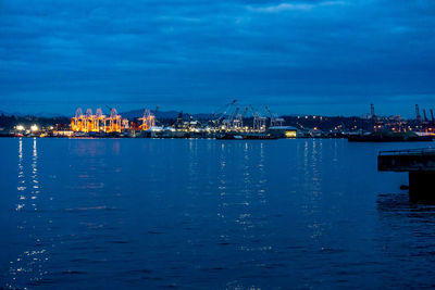 Illuminated pier by sea against sky at night