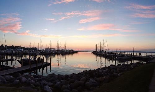 Boats in sea at sunset