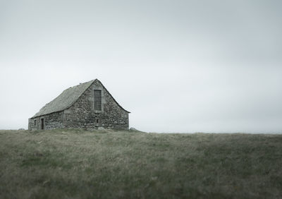 Old house on field against sky