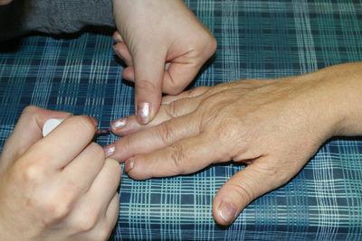 Cropped image of hands applying nail polish