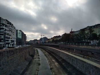 Railroad tracks in city against sky