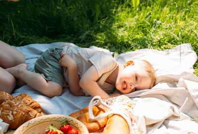 Boy child preschooler on a picnic. smiles, eating cherries and enjoying summer.