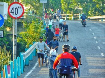 Rear view of people walking on road in city