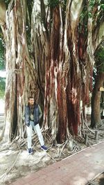 Full length of woman standing on tree trunk