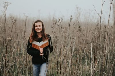 Portrait of smiling girl standing on field