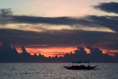 Silhouette sailboats in sea against sky during sunset
