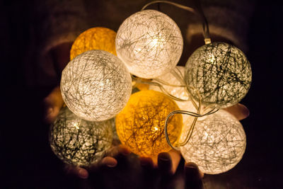 Close-up of illuminated lighting equipment against black background