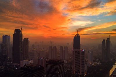 Aerial view of buildings in city during sunset