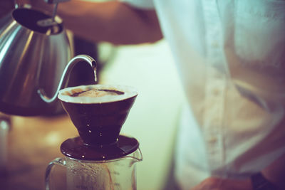 Midsection of barista preparing brewed coffee at cafe