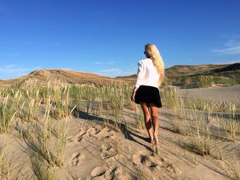 Rear view of woman on sand dune