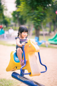 Cute girl playing on outdoor play equipment in playground