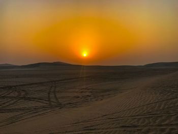 Scenic view of desert against sky during sunset