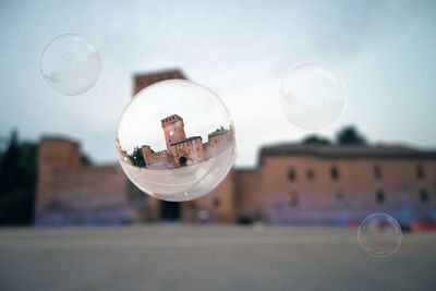 Close-up of bubbles in glass against sky