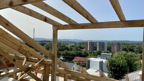 Built structure by trees and buildings against sky
