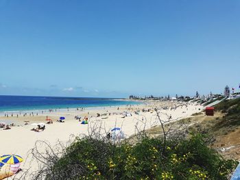 Scenic view of beach against clear blue sky