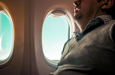 Low angle view of man sitting in airplane against sky