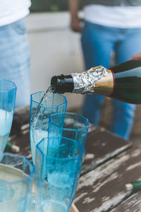 Close-up of hand holding glass bottle on table