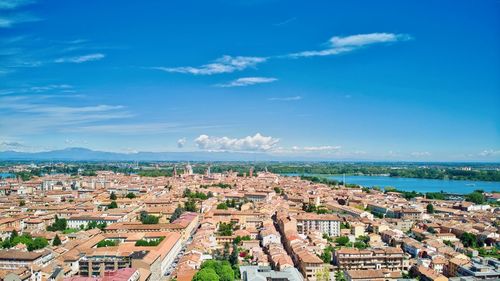 High angle view of townscape by sea against blue sky