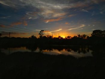 Scenic view of lake against sky at sunset