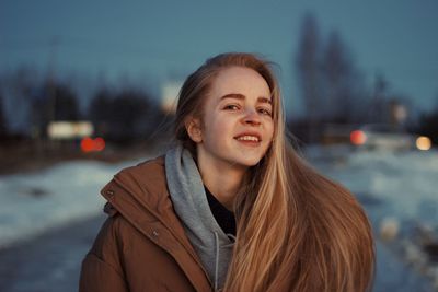 Portrait of young woman standing against sky