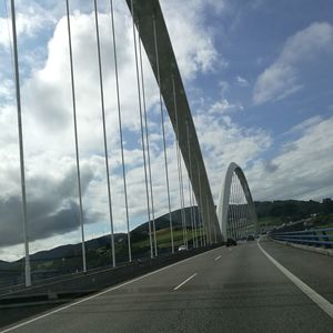 View of suspension bridge against cloudy sky