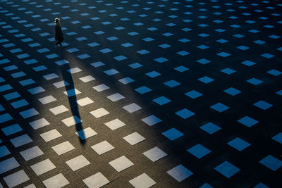 High angle view of man walking on tiled floor