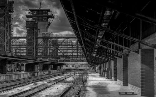 Railroad tracks in city against sky