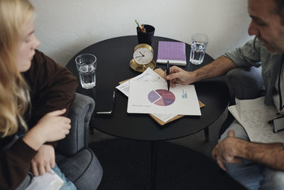 Male counselor discussing over chart with female student in school office