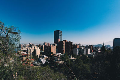 View of cityscape against clear blue sky