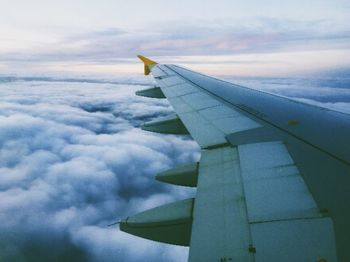 Cropped image of airplane against cloudy sky